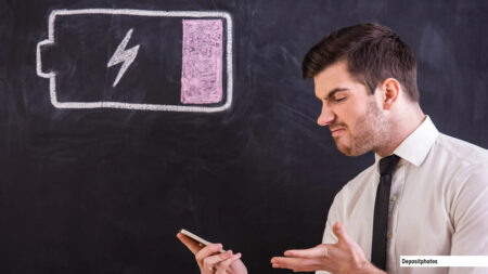 Homme frustré regardant la batterie de son smartphone se vider très rapidement